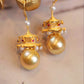 Close view of layered pavilion roofs, imitation pearls and red accents on the earrings