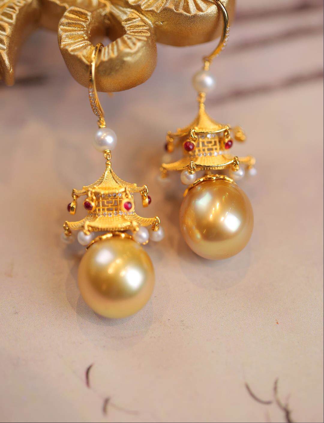 Close view of layered pavilion roofs, imitation pearls and red accents on the earrings