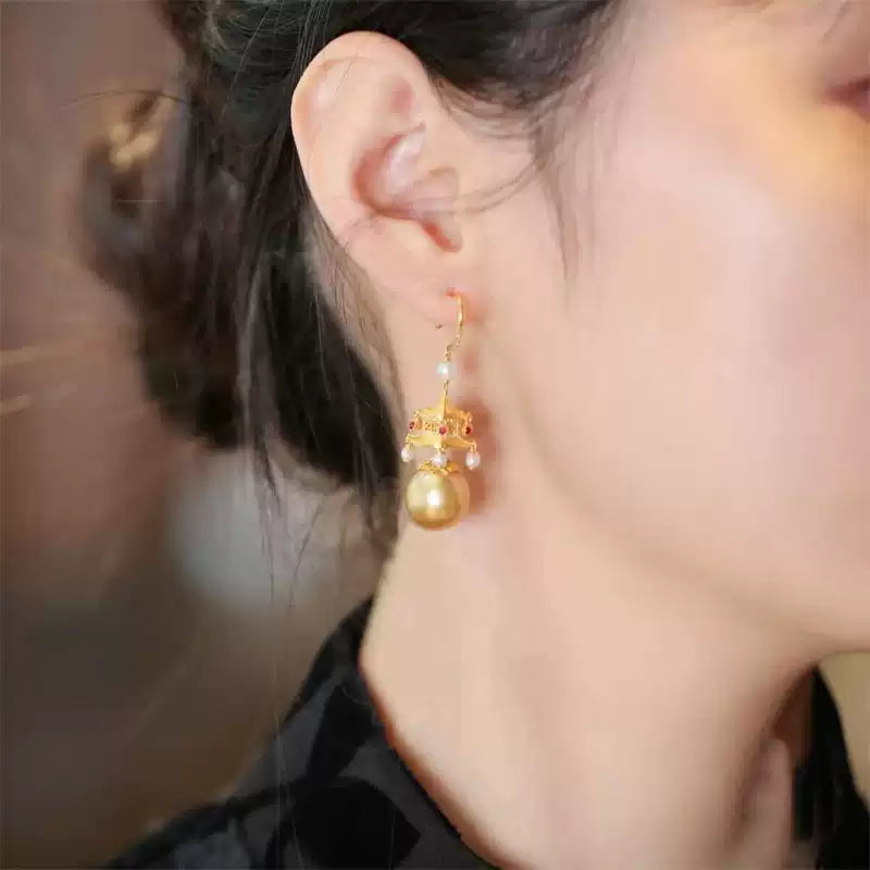 Gold-tone pavilion drop earring shown worn on an ear