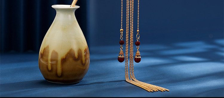 Gold chain tassel and red bead detail