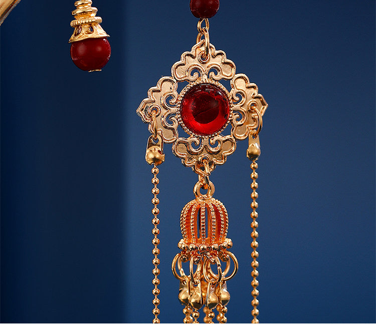 Gold filigree tassel pendant detail with red bead
