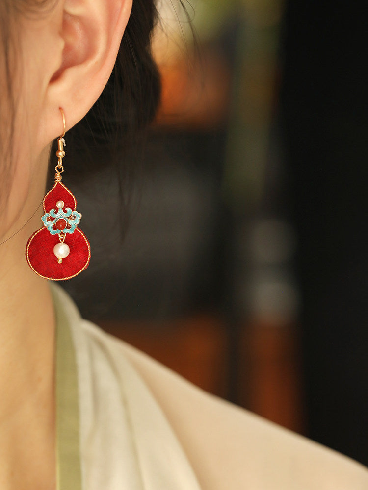 Red gourd drop earring worn, showing the turquoise floral connector