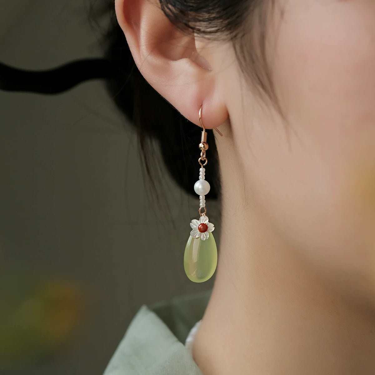 Green agate floral drop earring worn on a pierced ear; silver hook option