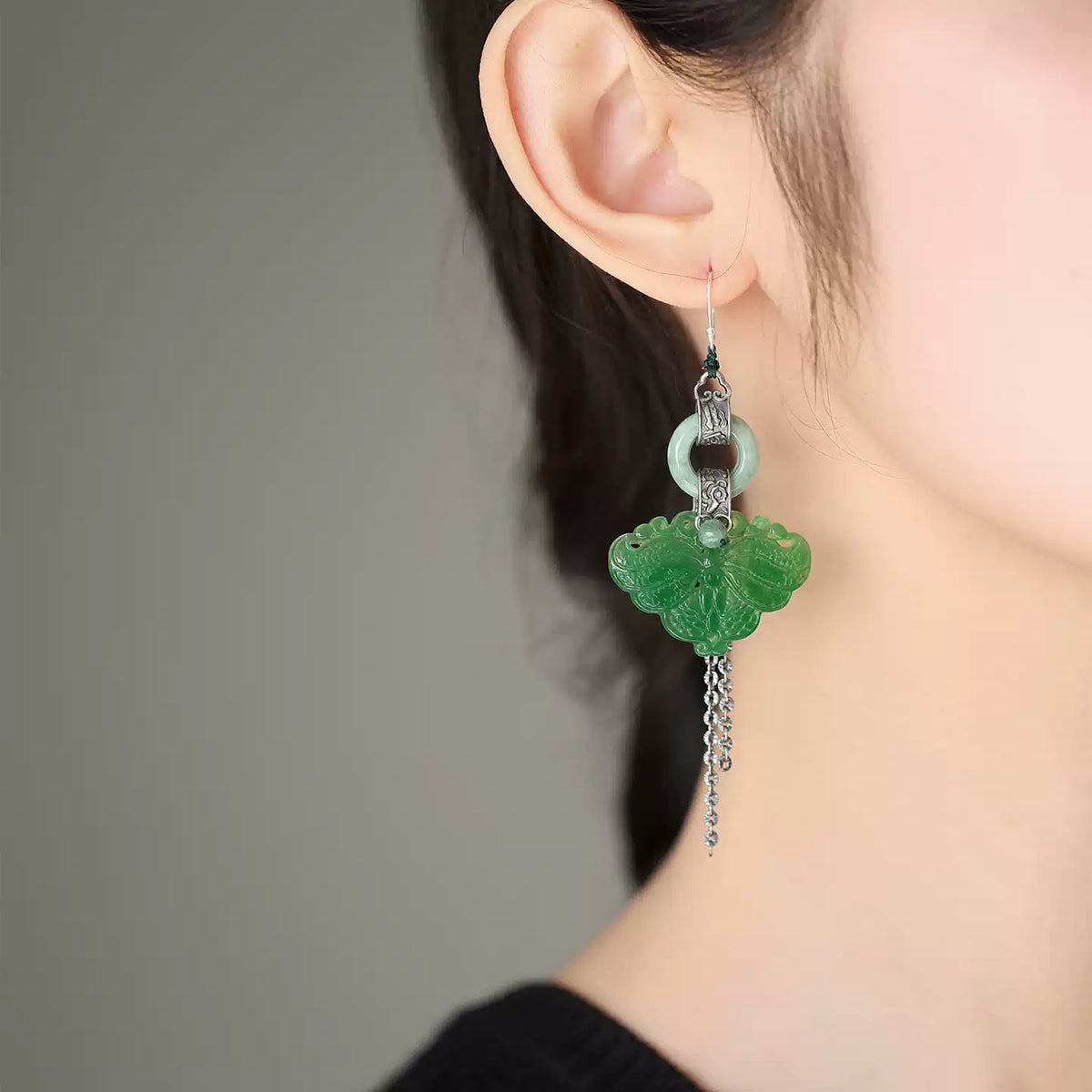 Green butterfly tassel earring styled on ear