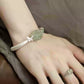 Green faux jade-style floral cuff bracelet worn on the wrist