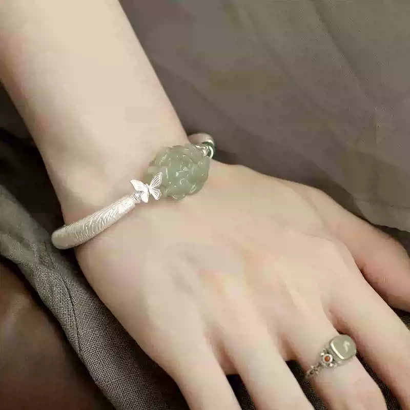 Green faux jade-style floral cuff bracelet worn on the wrist