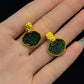 Front detail of the green and gold-tone garden-window stud earrings