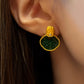 Green and gold-tone garden-window stud earring shown worn on an ear