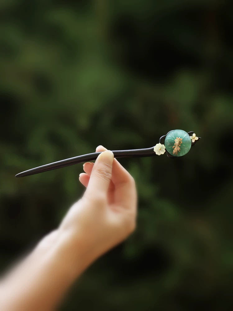 Green lotus-leaf hairpin with dark stick and gold-tone ornament