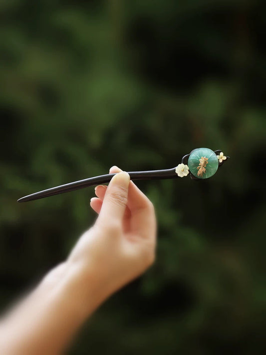 Green lotus-leaf hairpin with dark stick and gold-tone ornament
