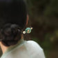 Green lotus-leaf hairpin styled in a bun