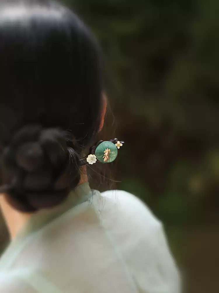 Green lotus-leaf hairpin styled in a bun