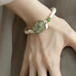 Close-up view of the carved green peony and butterfly bracelet