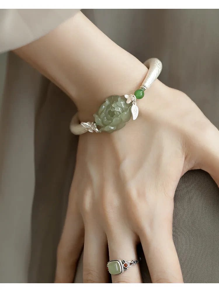 Close-up view of the carved green peony and butterfly bracelet