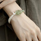 Textured curved copper cuff with green carved floral centerpiece