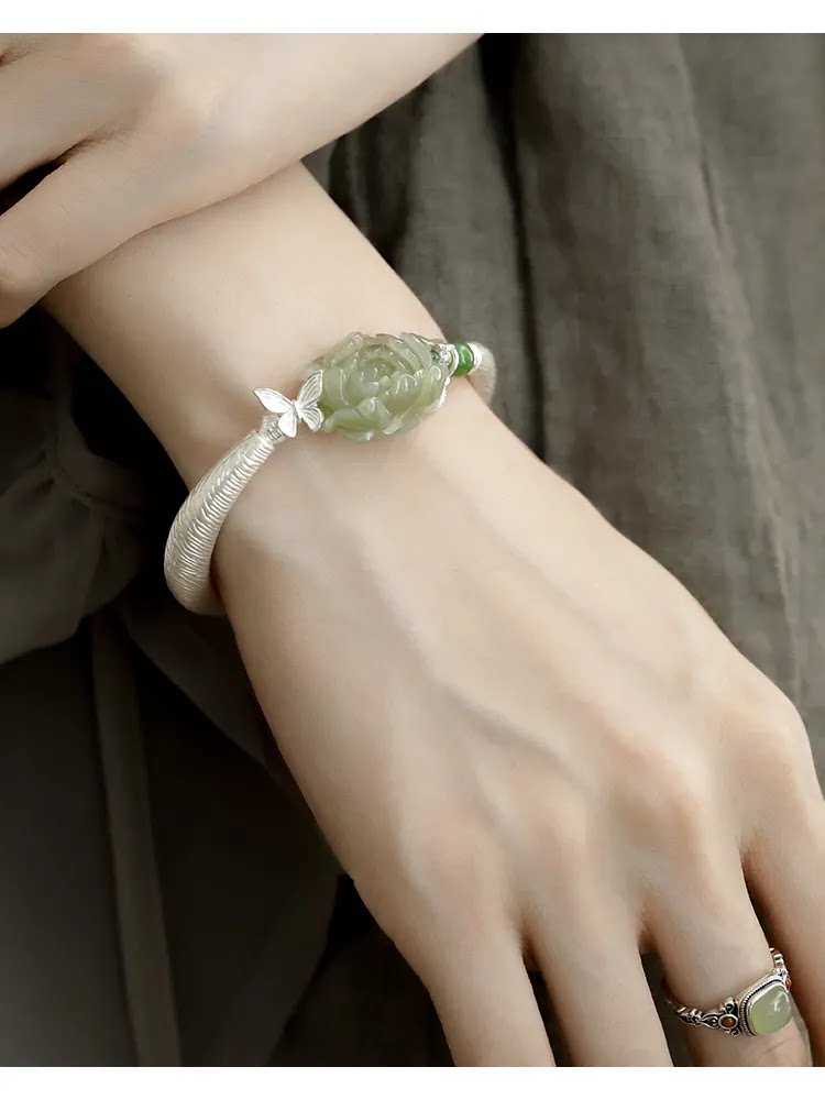 Textured curved copper cuff with green carved floral centerpiece