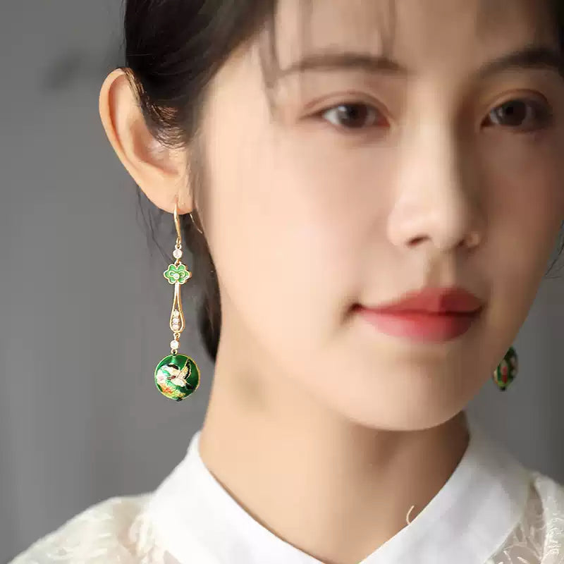 Model wearing a long green floral drop earring