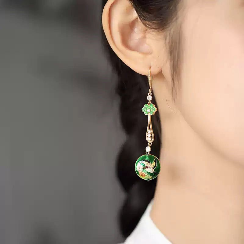 Green floral drop earring shown worn on the ear
