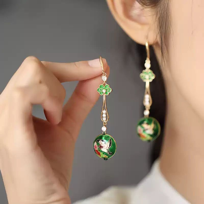 Green ruyi-style drop earring shown beside a hand and on the ear