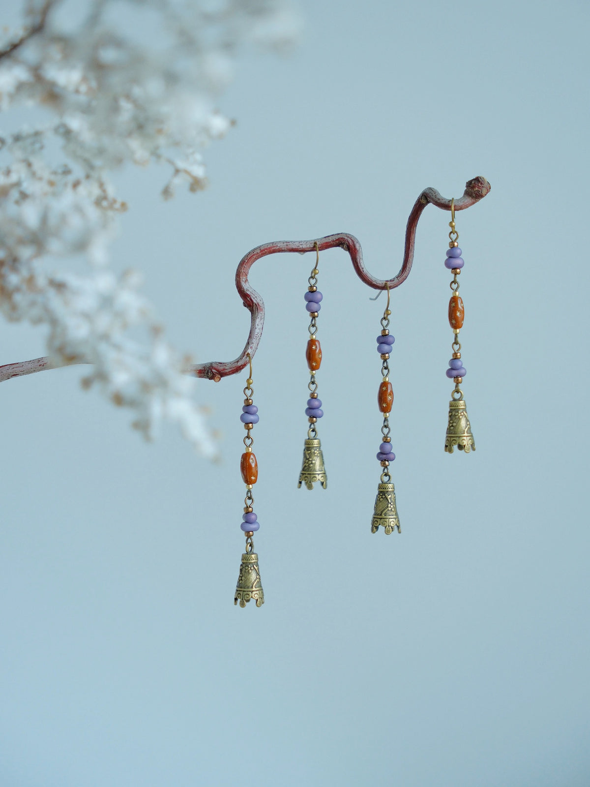 Hua Ling earrings displayed on a branch; each order includes one pair