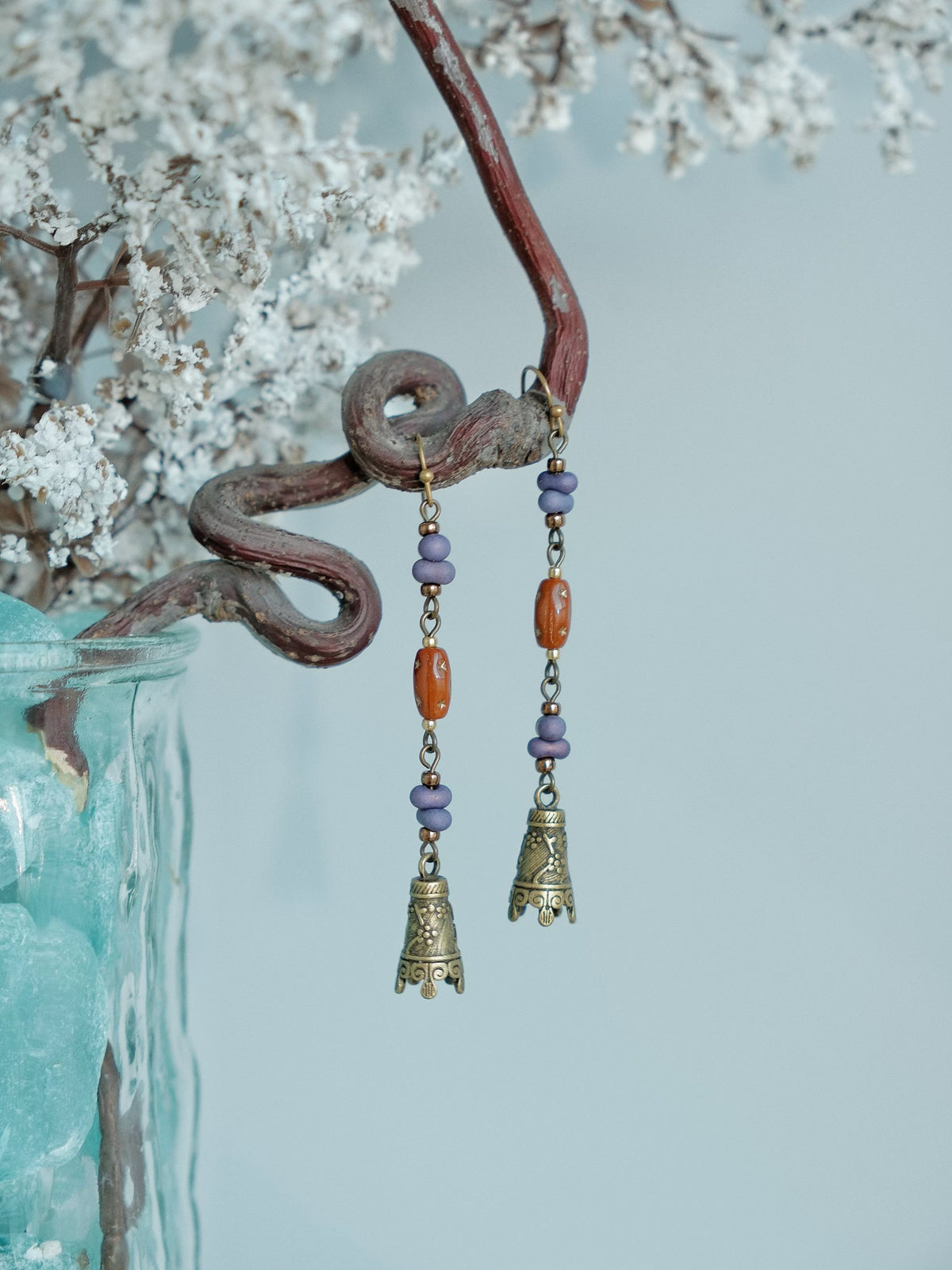 Bell-shaped charms and purple beads on Hua Ling dangle earrings