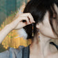 Long Chinese-inspired bell earrings shown beside the face