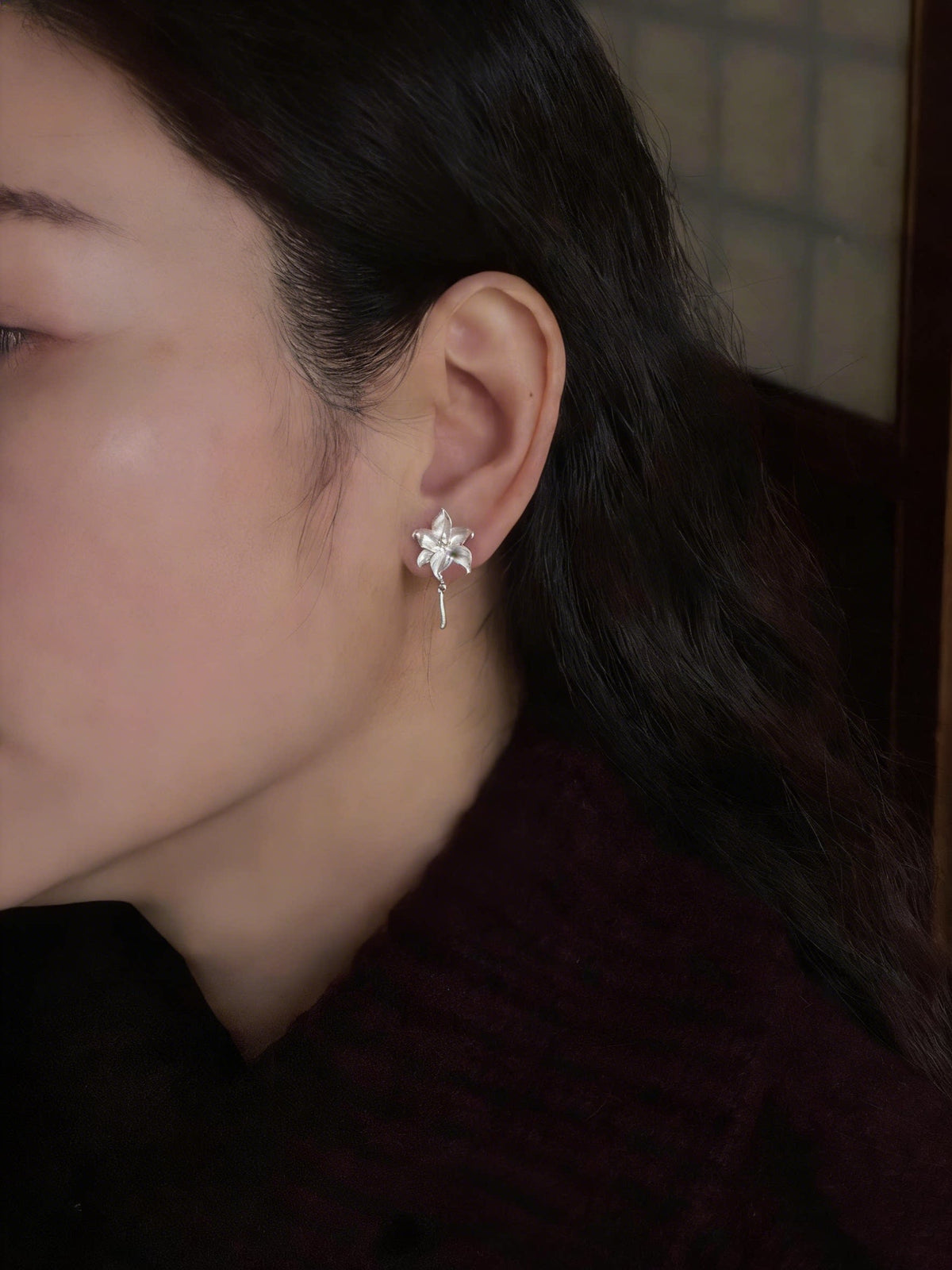 Lily flower drop stud earring shown worn on the ear