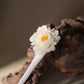 Close-up of the layered ceramic peony flower on a hairpin