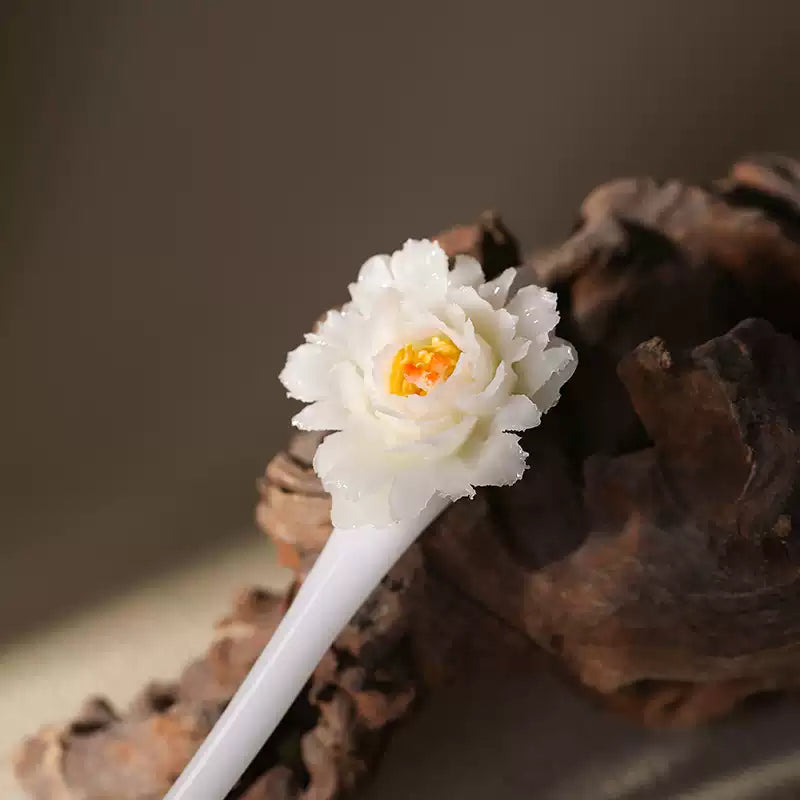 Close-up of the layered ceramic peony flower on a hairpin
