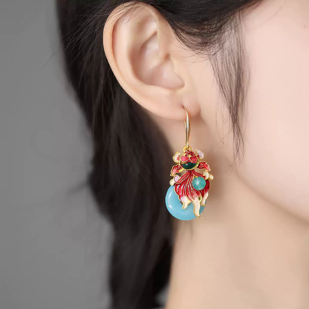 Close-up of a koi fish earring worn on the ear