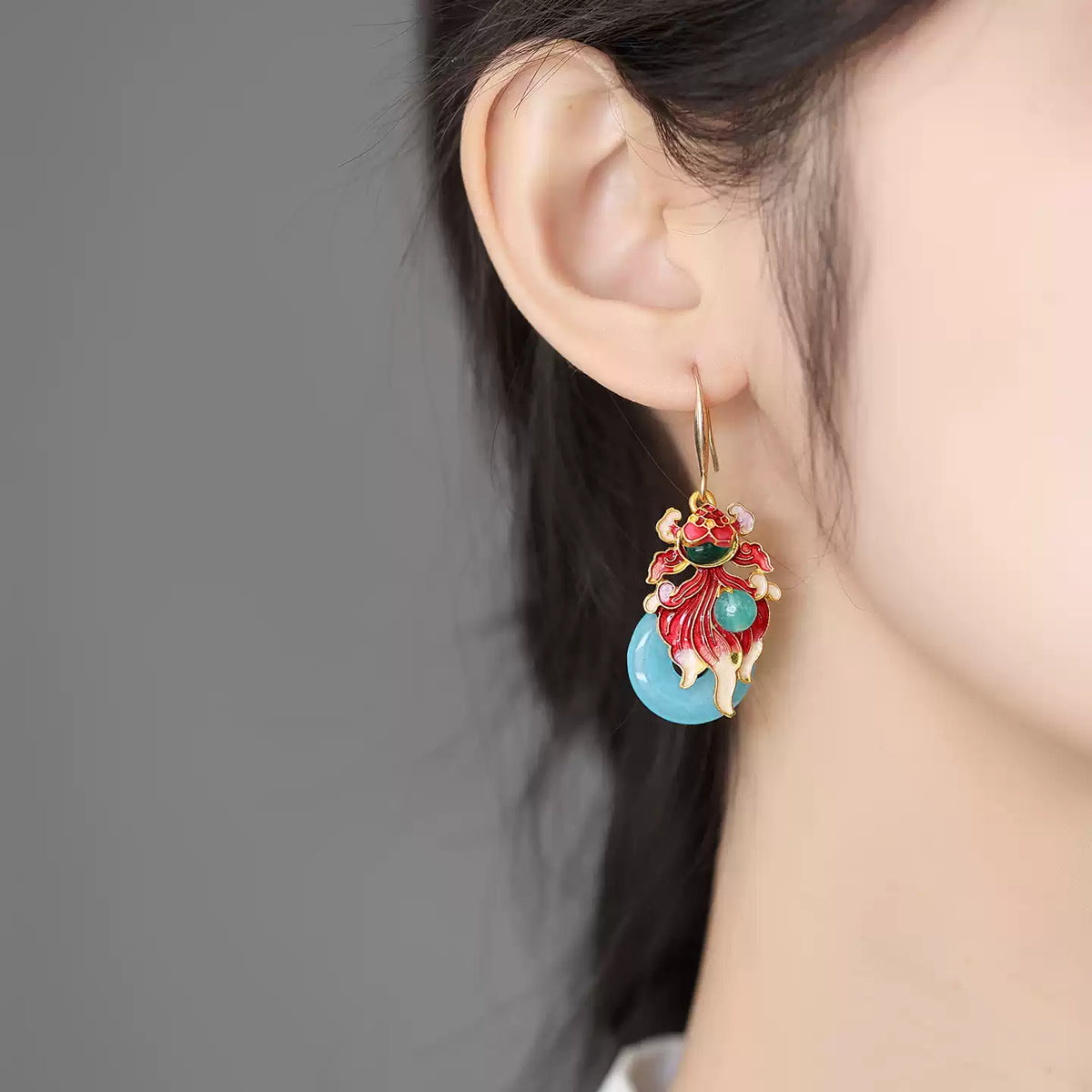 Side view of the koi fish drop earring worn on the ear