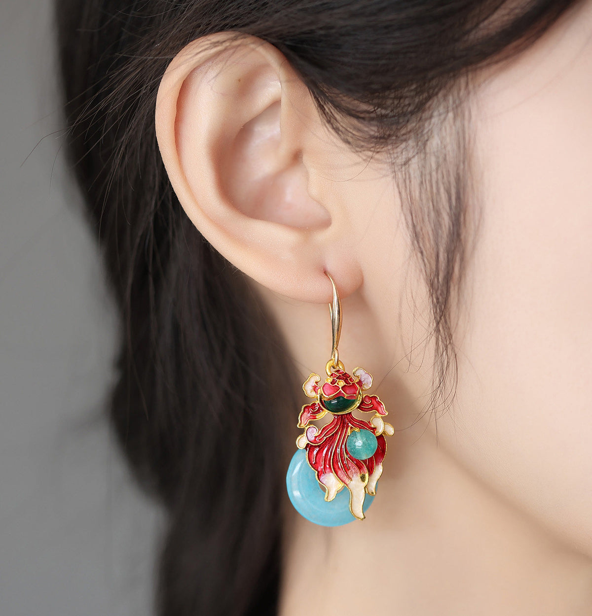 Koi fish drop earring shown worn from the side
