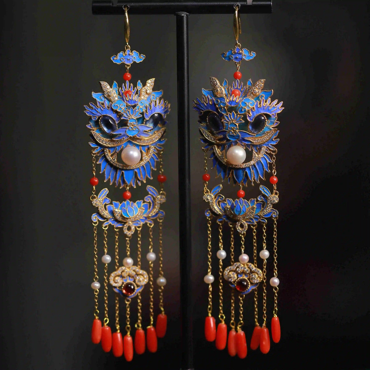 Lion-dance tassel earrings displayed together on a dark stand