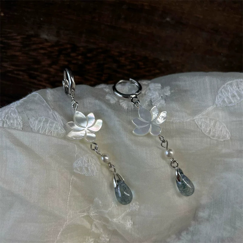 Mother-of-pearl lotus hoop earrings on sheer embroidered fabric