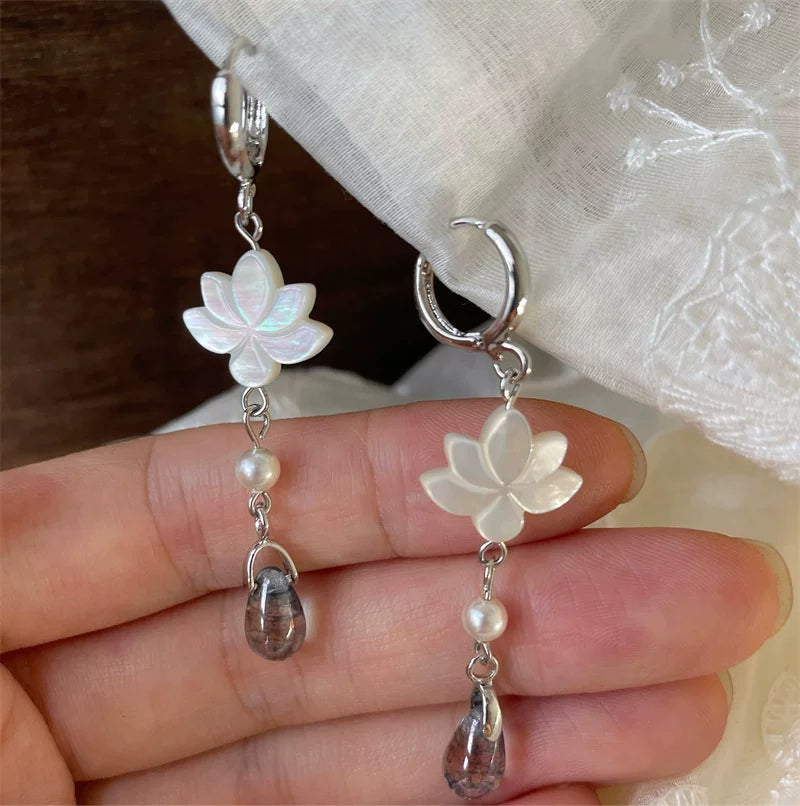Close-up of white mother-of-pearl lotus flowers and glass teardrops