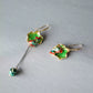 Pair of green koi and lotus leaf earrings laid flat