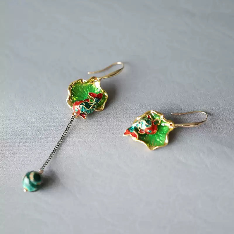 Pair of green koi and lotus leaf earrings laid flat