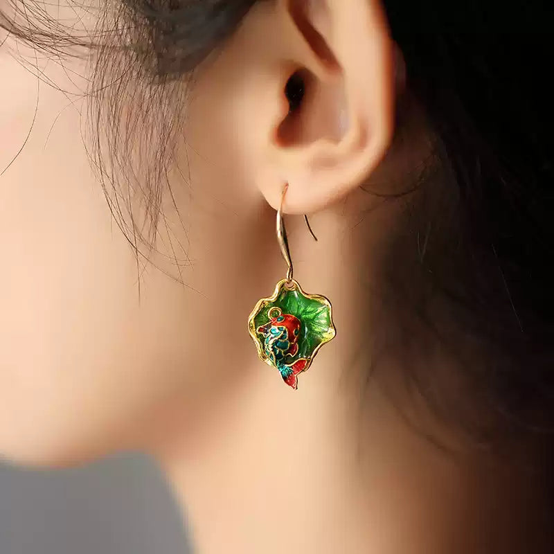 Green koi fish drop earring shown worn on the ear