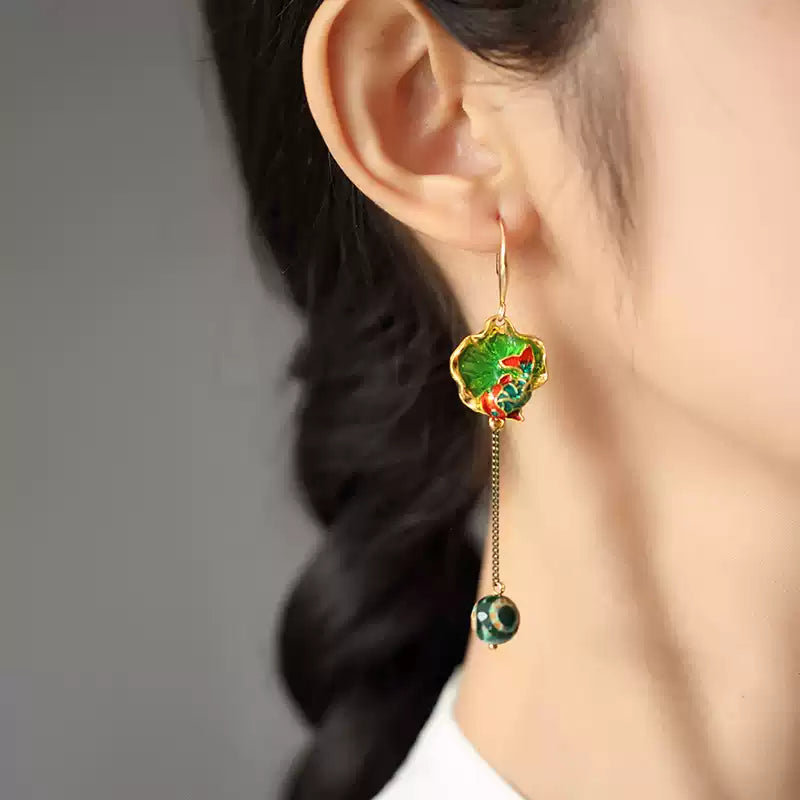 Close view of the green fish motif earring worn