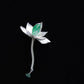Sculpted lotus waterdrop brooch with green accent on dark background