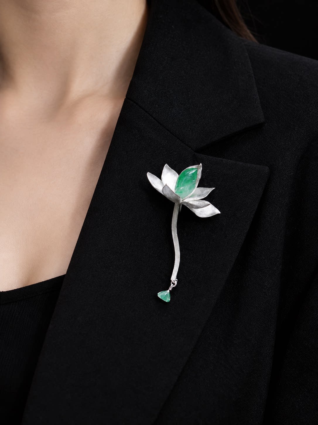 Close view of lotus waterdrop brooch worn on a blazer