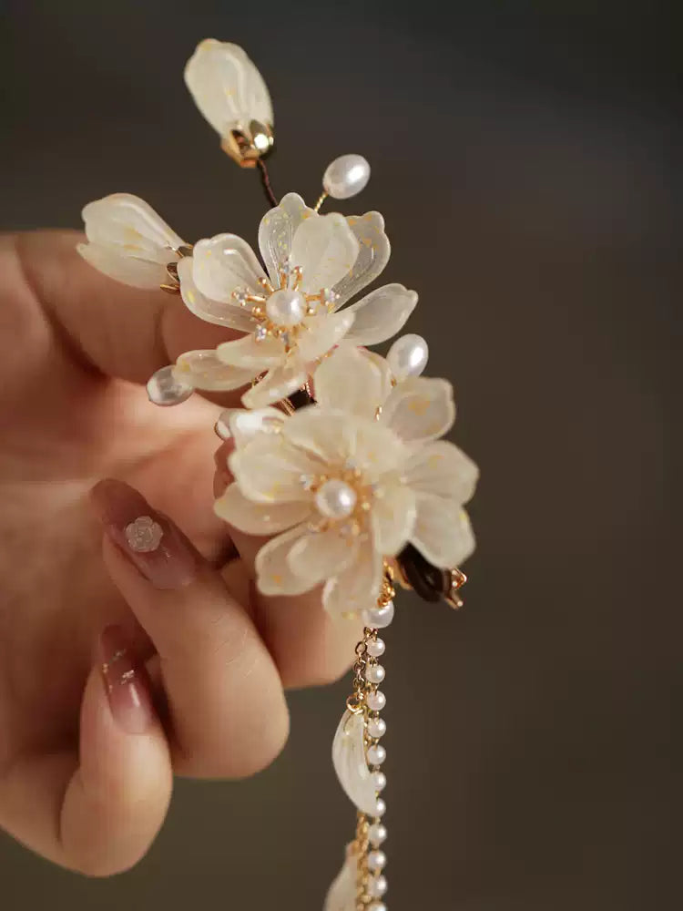 Magnolia floral side clip with pearl-like drops, held in hand