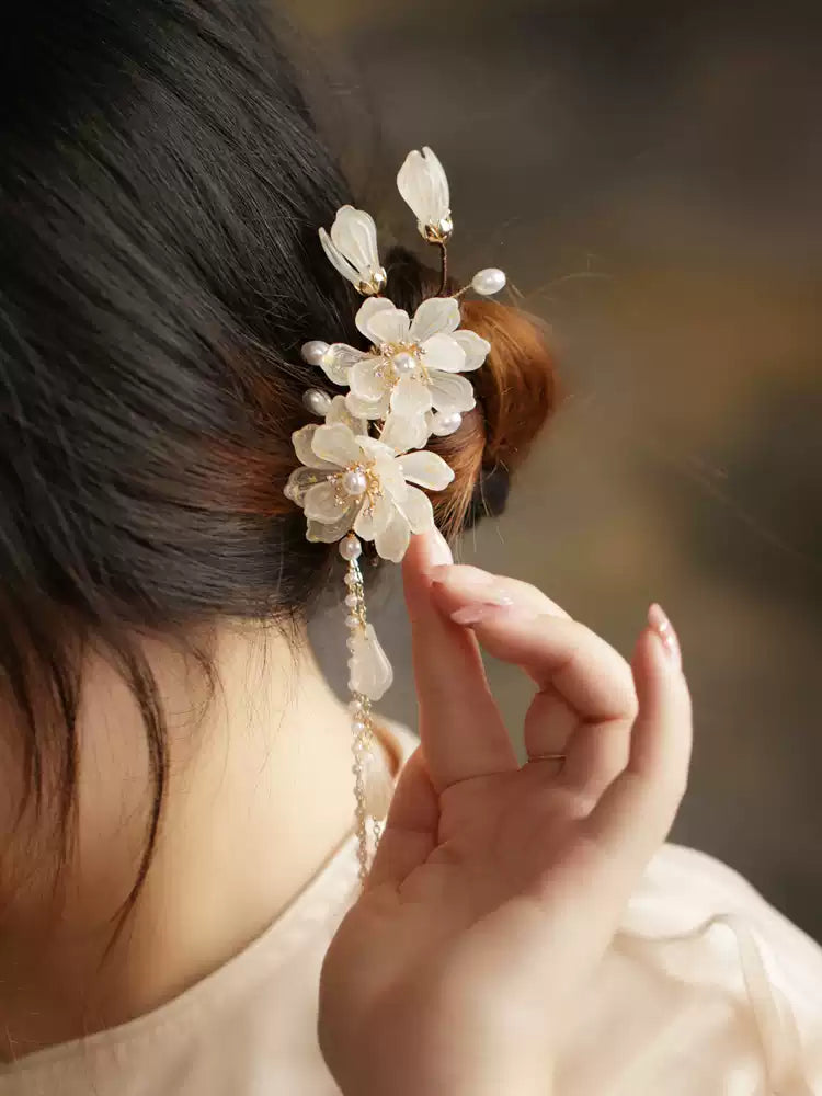 Magnolia tassel hair clip shown in a hand for scale
