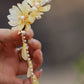 Two-tone magnolia and tassel hair clip close-up
