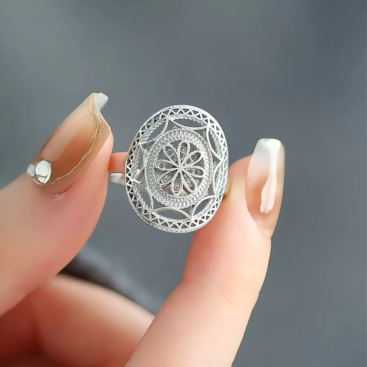 Close-up of the ring's floral relief and lace-like cutout details