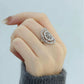 Silver-tone openwork floral ring shown worn on a finger