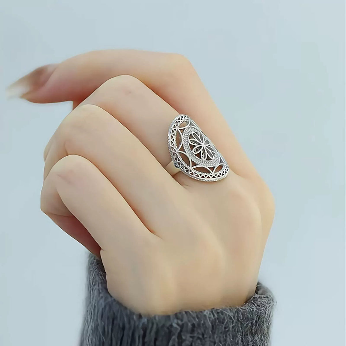 Silver-tone openwork floral ring shown worn on a finger