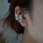 Side view of the orchid ear cuff worn on the ear