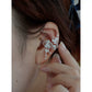 Close-up of the orchid ear cuff worn on the ear