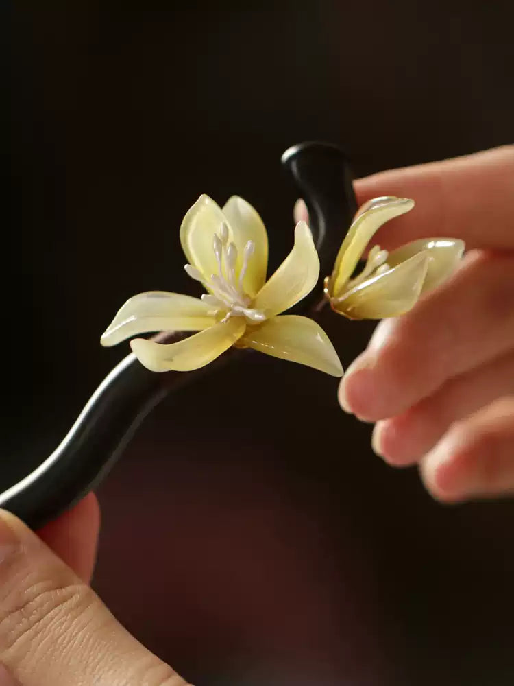 Close-up of an orchid hair stick held in hand